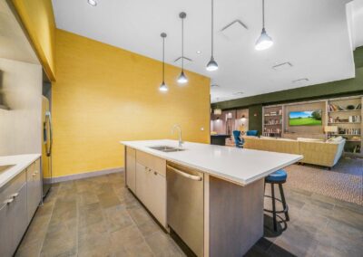 Newly updated resident kitchen featuring stainless steel appliances with view of lounge area and TV at The Packard Motor Car Building apartment community in Center City
