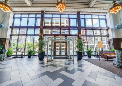 The grand lobby of the Packard apartment building with floor to ceiling windows, glass doors and chandeliers