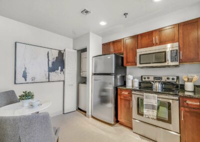 Kitchen with stainless steel appliances, washer and dryer, and seating area at The Packard Motor Car Building apartments in Philadelphia, PA
