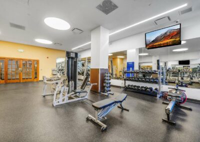 Renovated apartment community fitness center featuring state-of-the-art equipment and free weights at the Packard Motor Car Building